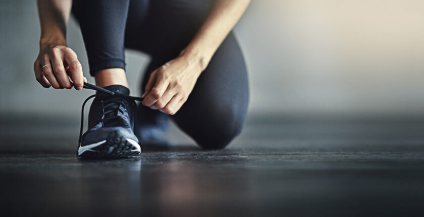 femme faisant les lacets de sa chaussure