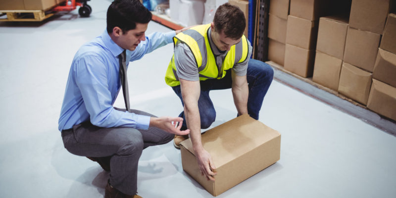 Manager training worker for health and safety measure in a large warehouse manager formant un travailleur pour une mesure de santé et de sécurité dans un grand entrepôt