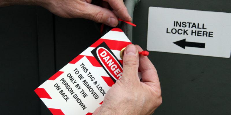 lock out tag out electrician placing a lock out tag out tag on electrical equipment