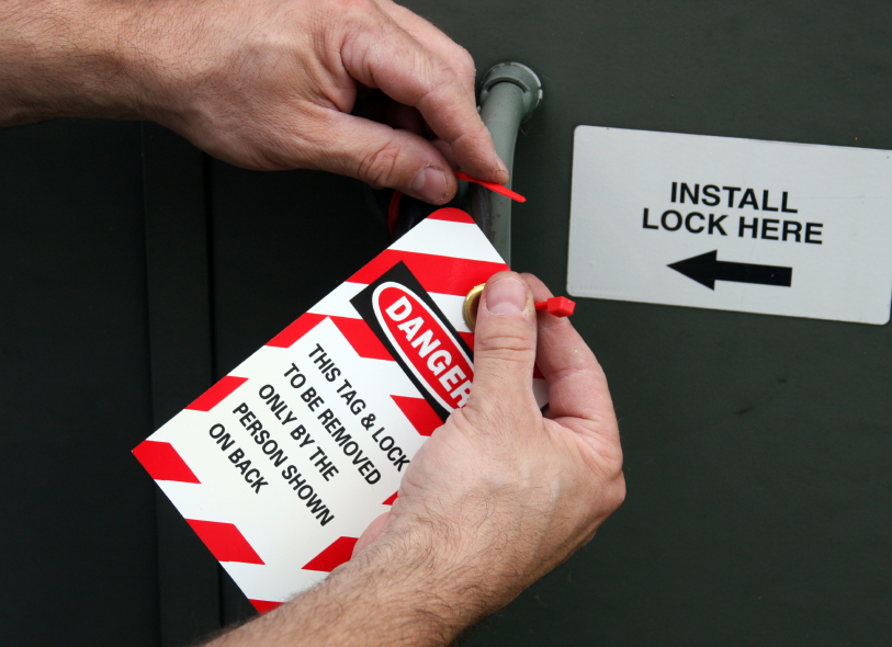 electrician placing a lock out tag out tag on electrical equipment