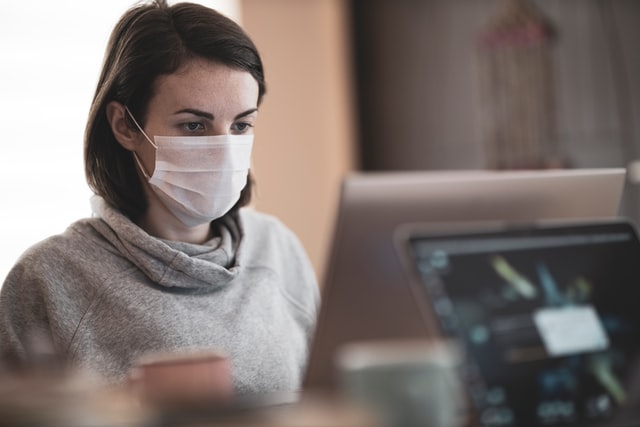 Femme masquée devant son ordinateur